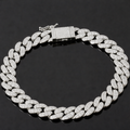The VLTED 10mm Iced Cuban Link Bracelet, a silver bracelet encrusted with small, sparkling diamonds and finished with a rectangular clasp, is displayed on a black background in a circular shape.